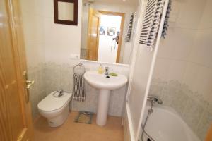 a bathroom with a sink and a toilet and a mirror at AR2B, coqueto apartamento en primera línea de playa in Villajoyosa +10 photos