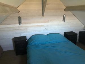 1 dormitorio con 1 cama azul y 2 altavoces en Accès direct mer. Plage du Débarquement, en Ouistreham