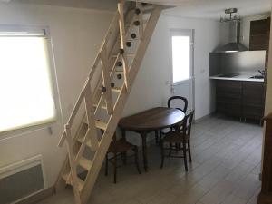 een houten trap in een keuken met een tafel en een eetkamer bij Accès direct mer. Plage du Débarquement in Ouistreham
