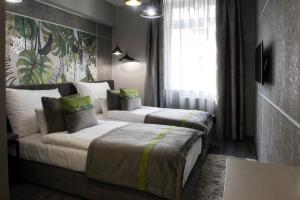 a hotel room with two beds and a couch at Hotel Central in Kecskemét