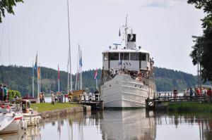 ein großes Boot an einem Dock anlegt in der Unterkunft Kanalmagasinets Pensionat in Söderköping