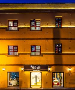 a large yellow building with windows and a store at Moon and Chalice Boutique Hotel in Kunming