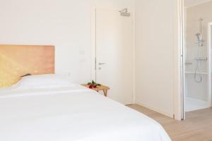 a bedroom with a white bed and a shower at Hotel Mediterraneo in Sottomarina