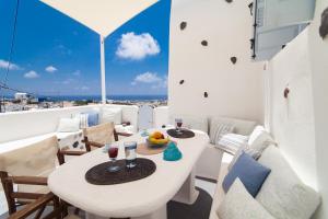 Una mesa blanca y sillas en un balcón con vista. en Villa Angels Unique traditional Villa, en Emporio