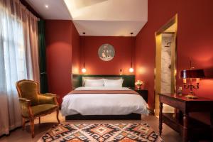 a bedroom with red walls and a bed and a chair at Moon and Chalice Boutique Hotel in Kunming