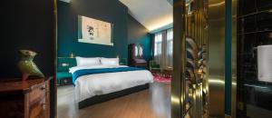 a bedroom with a bed with a blue wall at Moon and Chalice Boutique Hotel in Kunming