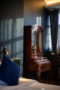 a wooden dresser with a mirror on top of a bed at Moon and Chalice Boutique Hotel in Kunming
