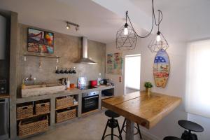 a kitchen with a wooden table and a counter at House Beach in Costa da Caparica