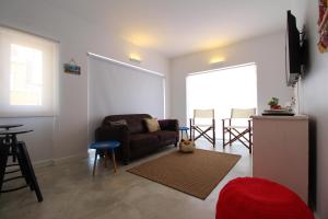 a living room with a couch and a table at House Beach in Costa da Caparica