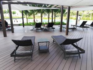 a group of chairs and tables on a deck at Green Haven Homestay in Pasir Gudang