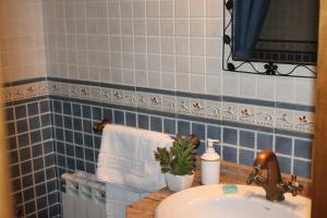 a blue tiled bathroom with a sink and a towel at Apartamentos Rurales Rosendo: "La Mejorana" in Capileira