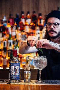 Een man maakt een drankje in een bar. bij St Christophers Inn at The Winston in Amsterdam