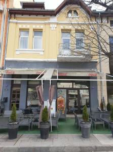 um restaurante com mesas e cadeiras em frente a um edifício em ВАЛЕНТИНО em Vratsa