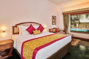 a bedroom with a large bed and a window at The Ummed Ahmedabad Airport in Ahmedabad