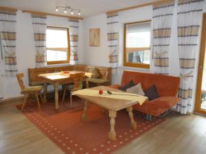 a living room with a couch and tables and windows at Holiday flat with swimming pool in Prackenbach in Viechtach