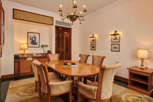 a dining room with a wooden table and chairs at The Ummed Ahmedabad Airport in Ahmedabad