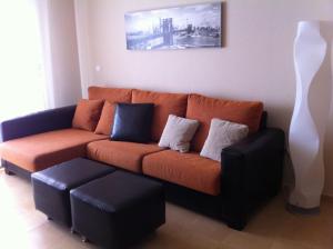 sala de estar con sofá naranja y jarrón blanco en CORMORANT SUITE, sea terrace & pools, en La Manga del Mar Menor