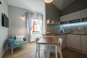 a kitchen and dining room with a table and chairs at Grand Apartments - Neptun Park Smile&Relax in Gdańsk
