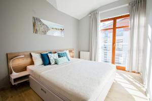 a bedroom with a large bed and a window at Grand Apartments - Neptun Park Smile&Relax in Gdańsk