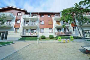 ein Apartmenthaus mit einem Spielplatz davor in der Unterkunft Grand Apartments - Neptun Park Smile&Relax in Danzig + 7 Fotos