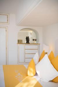 um quarto com uma cama com almofadas amarelas e brancas em Villa Yiara em Positano