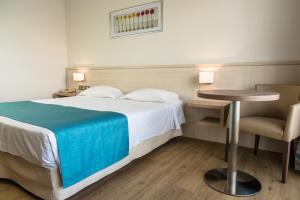 een hotelkamer met een bed, een tafel en een stoel bij Cynthiana Beach Hotel in Paphos City