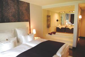 a bedroom with a large bed and a bath tub at Hotel Künstlerquartier Seezeichen in Ahrenshoop