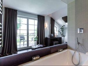 a large living room with a large tub in front of a window at Hotel Künstlerquartier Seezeichen in Ahrenshoop