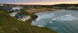 un cuerpo de agua con una playa y una ciudad en Number 19, en Bude