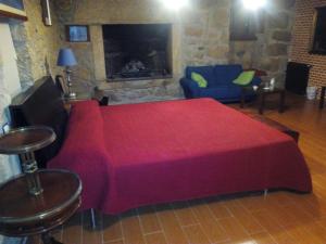 a large red bed in a room with a fireplace at Posada Palacio Manjabalago in Manjabálago