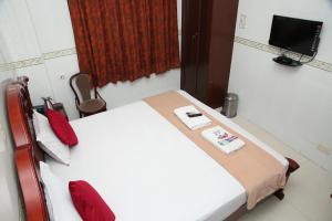 um pequeno quarto com uma cama e uma televisão em Grand View Residency Chennai em Chennai