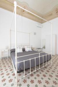 ein Schlafzimmer mit einem weißen Himmelbett in einem Zimmer in der Unterkunft Dimora CentroWell in Palermo