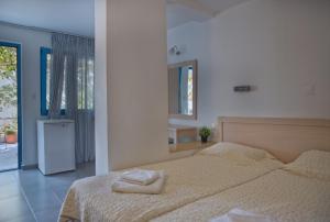 1 dormitorio con 1 cama con 2 toallas en Agios Pavlos Hotel, en Agios Pavlos