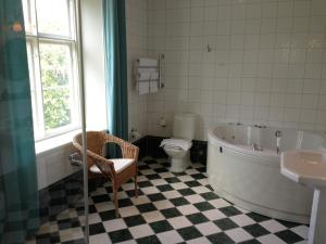 a bathroom with a tub and a toilet and a sink at Vidbynäs Gård & Konferens in Nykvarn +21 photos