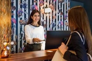 a woman standing at a desk talking to a woman at Manhattan Hotel in Frankfurt