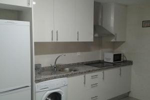 una cocina con fregadero y lavadora en Playa Mar, en Torre del Mar