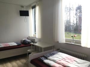 a bedroom with a bed and a desk and a window at Pension Highway 3 in Bielefeld