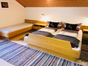 a bedroom with two beds and a rug at Haus Stabentheiner in Au im Bregenzerwald