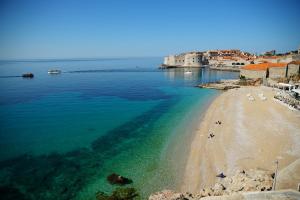 vista su una spiaggia con l'oceano e gli edifici di Dubrovnik Sunset Apartments a Dubrovnik
