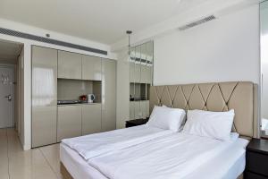 a bedroom with a large bed with white sheets at Netanya SeaView ApartHotel in Netanya