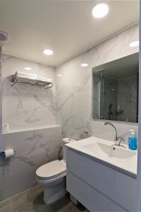 La salle de bains est pourvue d'un lavabo, de toilettes et d'un miroir. dans l'établissement Netanya SeaView ApartHotel, à Netanya