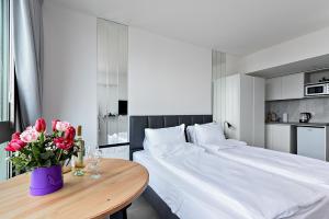 a bedroom with a large bed and a table with flowers at Netanya SeaView ApartHotel in Netanya