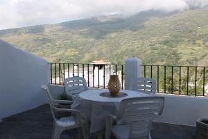 una mesa y sillas en un balcón con vistas en Apartamentos Rurales Rosendo: "Suite Veleta" en Capileira