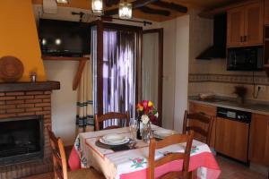 a dining room with a table and a kitchen at Apartamentos Rurales Rosendo: "Suite Veleta" in Capileira