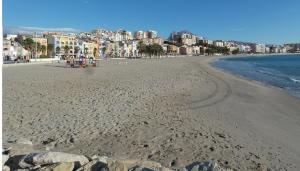 a view of a beach with buildings in the background at AR2B, coqueto apartamento en primera línea de playa in Villajoyosa