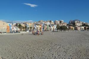 a sandy beach with a city in the background at AR2B, coqueto apartamento en primera línea de playa in Villajoyosa