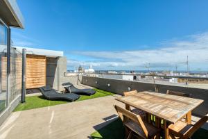a patio with a wooden table and chairs on a roof at Apartamentos Vegueta in Las Palmas de Gran Canaria