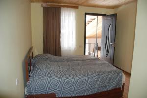 una camera da letto con un letto e una porta su un balcone di Gogi Jafaridze's Guesthouse a Mestia