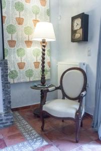 una lámpara y una silla junto a una mesa en Ostra Menalon Luxury Suites, en Kardharás