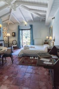 a bedroom with a bed and a desk and a table at Ostra Menalon Luxury Suites in Kardharás
